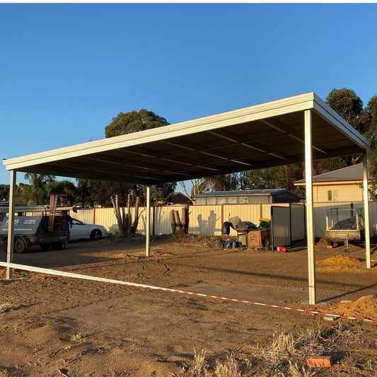 Carport with sloped roof and upright posts in an outdoor yard