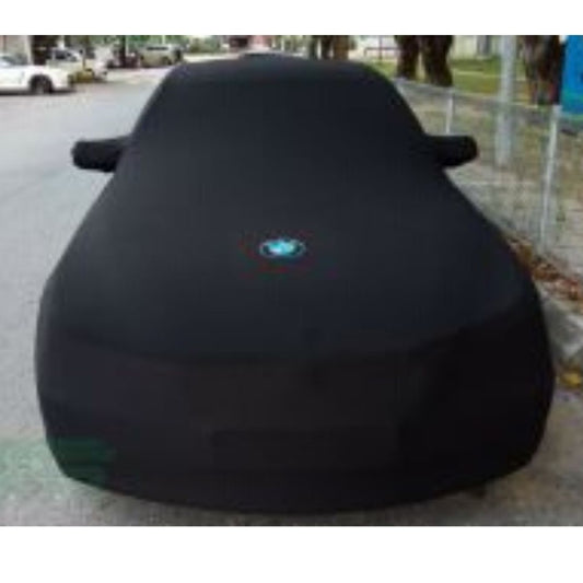 Dark indoor car cover fitted over the full vehicle, hood area centered